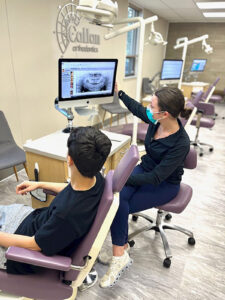 An orthodontist showing dental x-rays to a patient