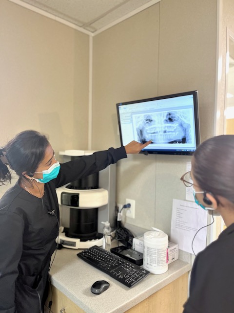 two female orthodontic assistants examine an X-ray of teeth callan orthodontics