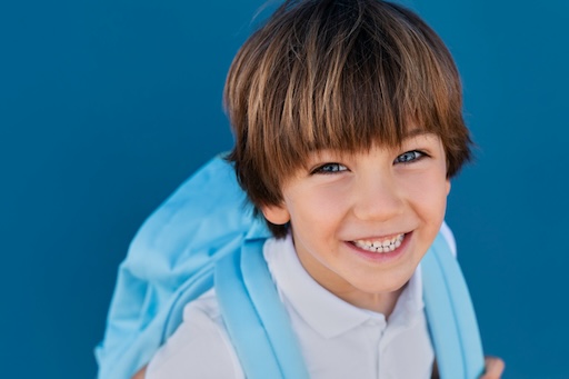 child wearing backpack smiling headgear callan orthodontics