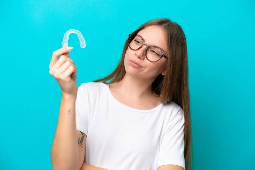 woman inspecting clear aligners callan orthodontics lawrenceville nj how old is too old for braces