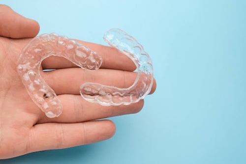 hand holding pair of retainers retainer replacement callan orthodontics lawrenceville nj