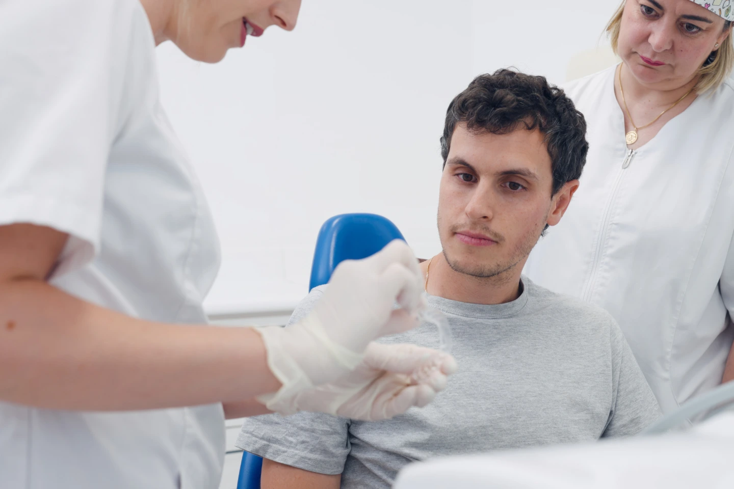 Invisalign Treatment Patient reviewing Invisalign aligner when switching from braces mid-treatment